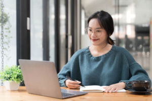 beautiful-women-student-studying-online-takes-notes-on-her-laptop-to-gather-information-about-her-work-smiling-face-and-a-happy-study-posture